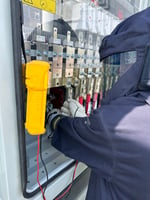 Adrian Electric electrician in arc-flash protective gear testing electrical equipment