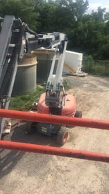 Boom lift positioned for elevated electrical work at an industrial site
