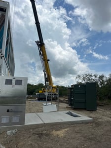 Crane setting industrial power equipment on a ground-up project in Victoria, Texas