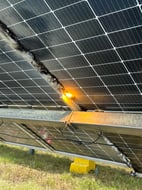 Solar farm panel rows with electrical work underway