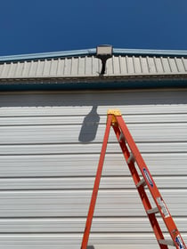 Exterior LED security light installed on a metal building
