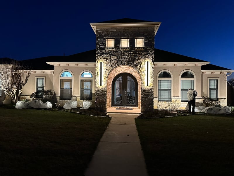 Exterior lighting installed by Adrian Electric on a stone home at night