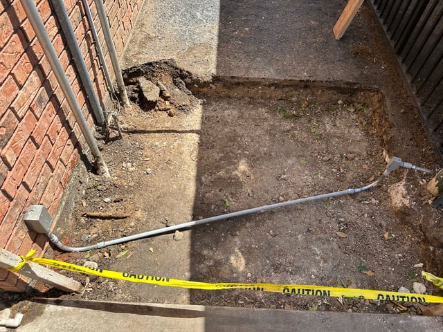 Trench with underground conduit run to a building