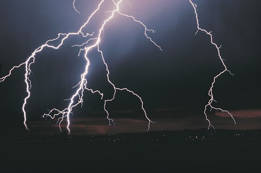 Vivid lightning strike illuminating stormy sky over Fort Bend, Texas, highlighting the need for grounding and surge protection by Adrian Electric.