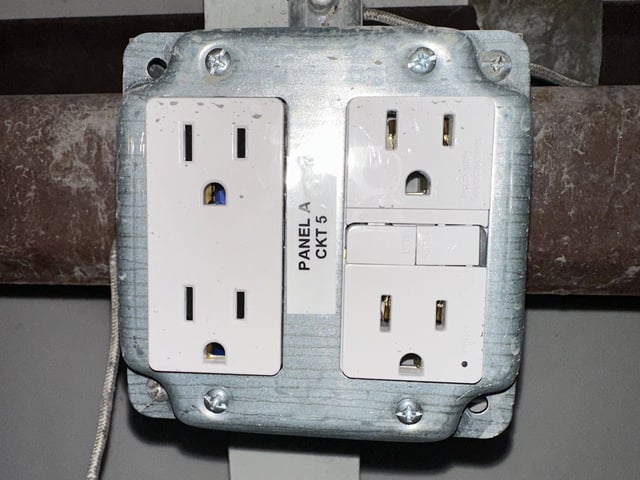 New GFCI receptacles in a commercial building in Bay City, each labeled with its panel and circuit