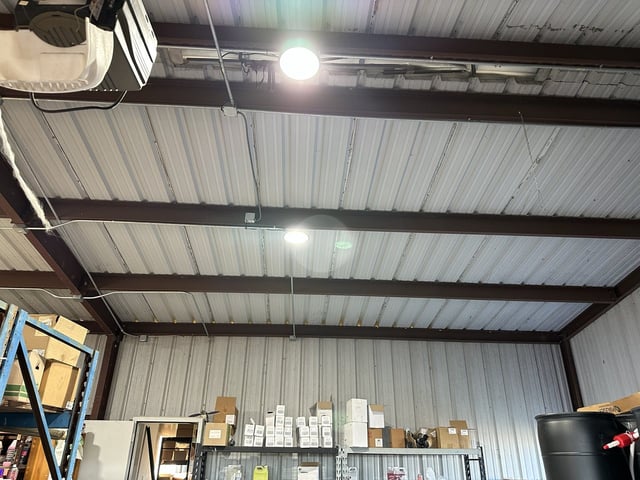 LED lights and EMT conduit with junction boxes on warehouse roof beams