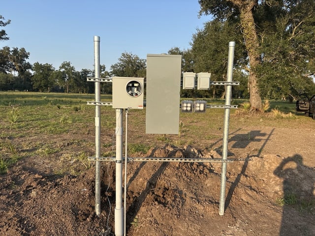 New meter rack with meter base, main disconnect and weatherproof receptacles on galvanized posts in Van Vleck, TX